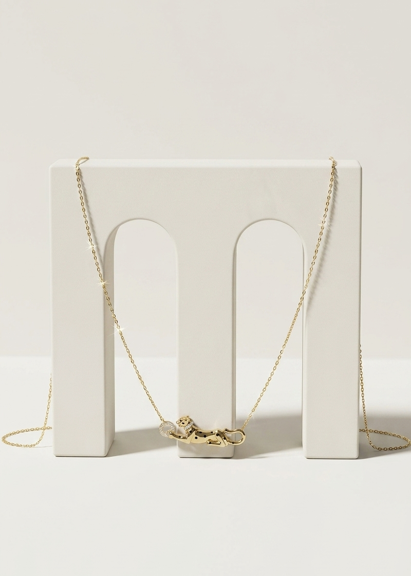 Gold necklace on a white stand with a white background