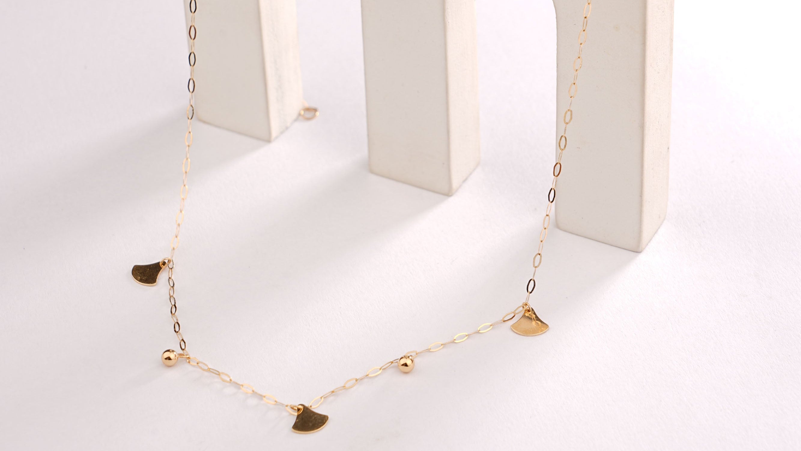 Necklace displayed in a white jewelry box on a light gray background