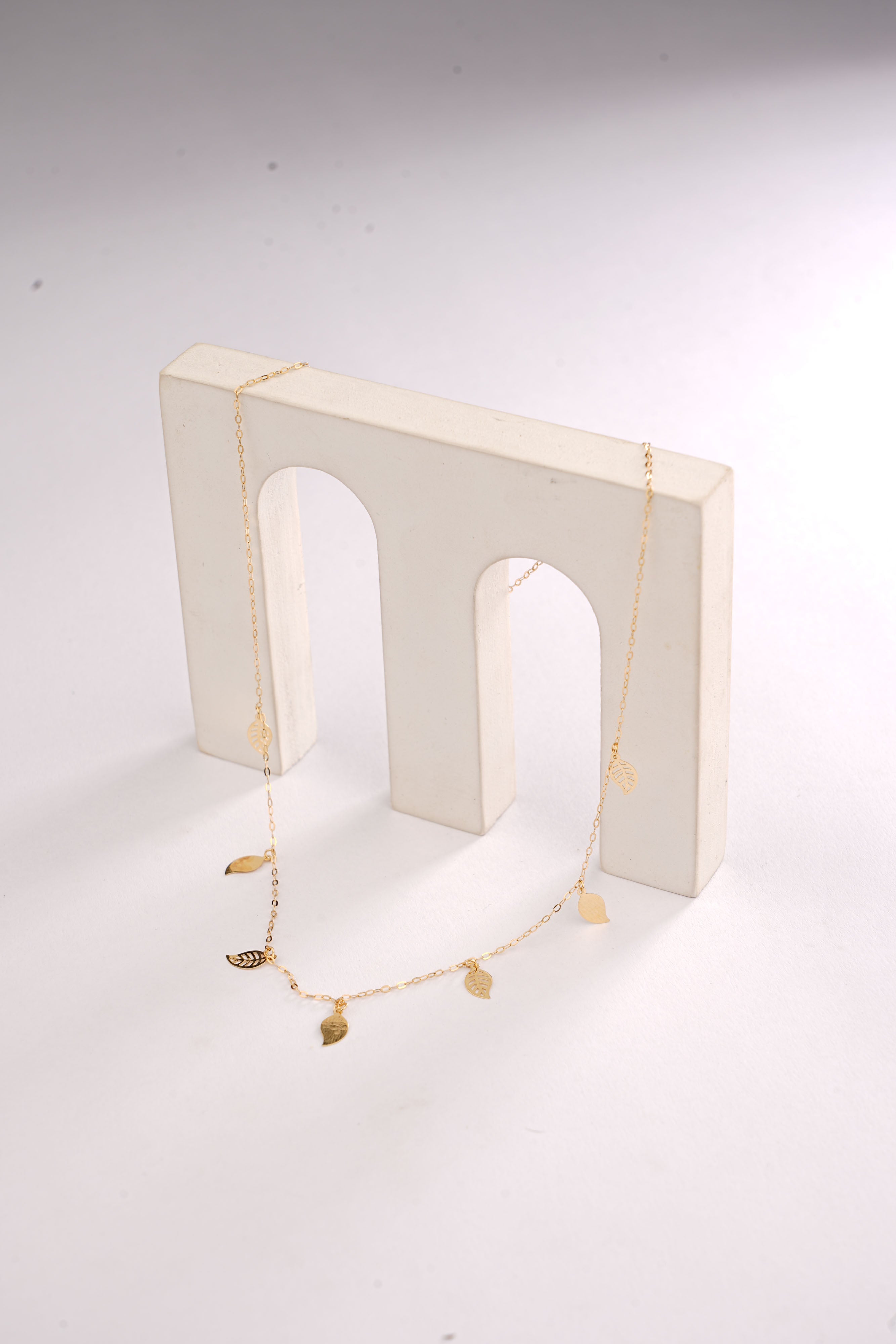 Necklace displayed on a white stand against a white background