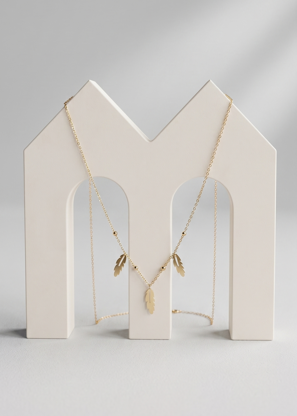 Necklace on a white jewelry stand against a light gray background