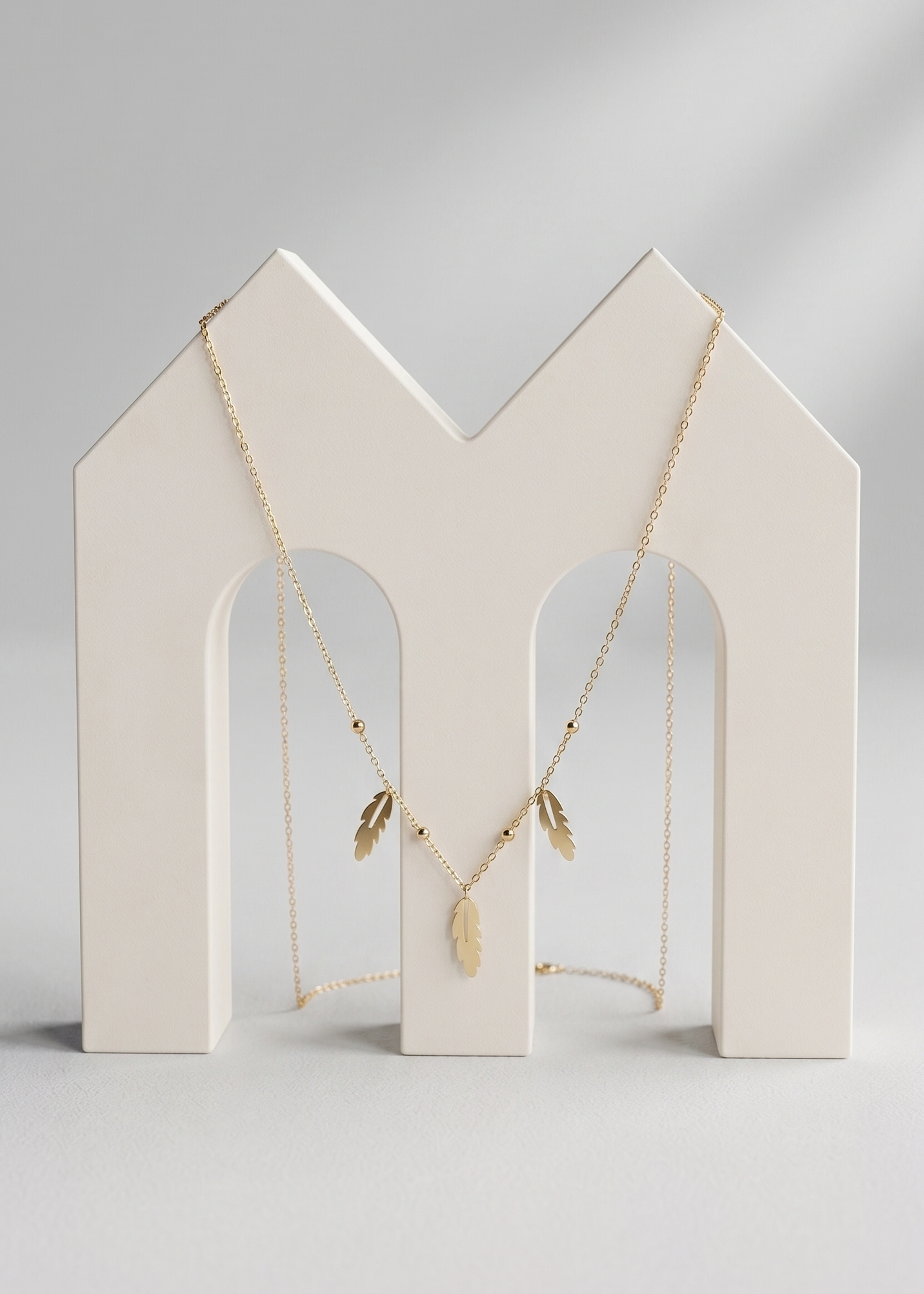 Necklace on a white jewelry stand against a light gray background
